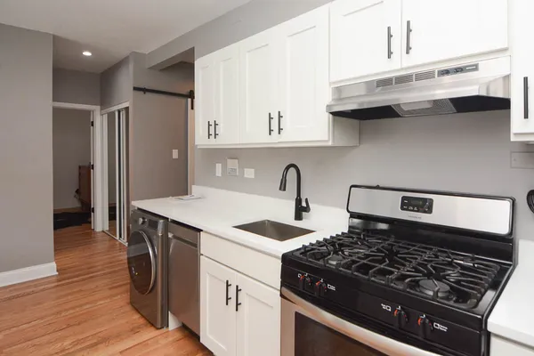 a kitchen with granite countertop a sink stove and cabinets