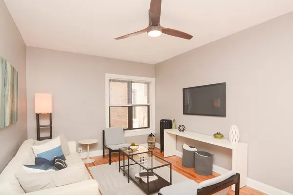 a living room with furniture a flat screen tv and a window