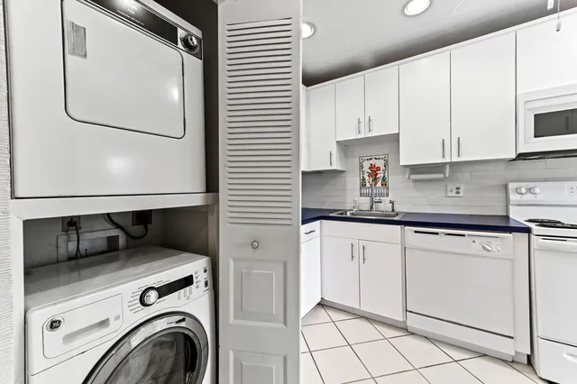 a kitchen with a refrigerator and white cabinets