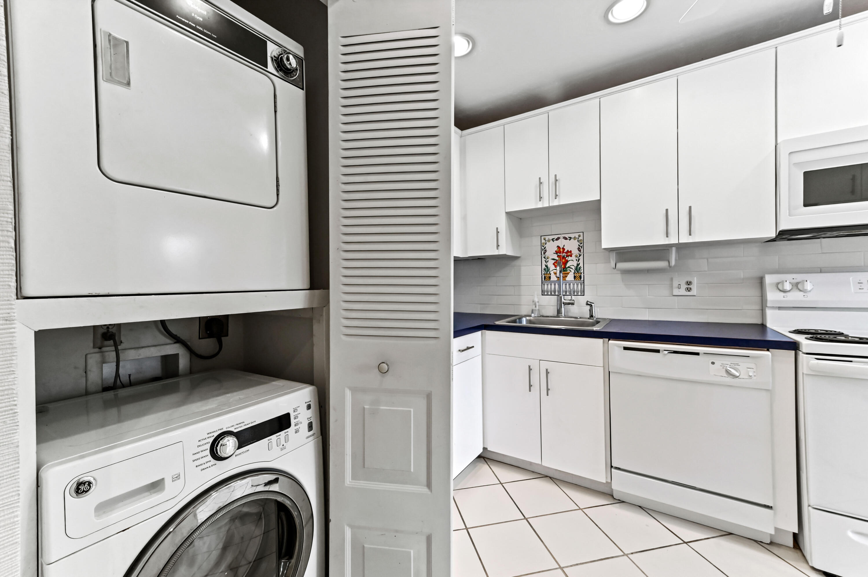 33 Southport Lane, Unit D Boynton Beach, FL 33436 - Photo 11 of 42 a kitchen with a refrigerator and white cabinets