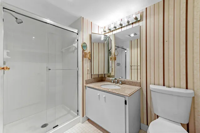 a bathroom with a granite countertop sink toilet and shower