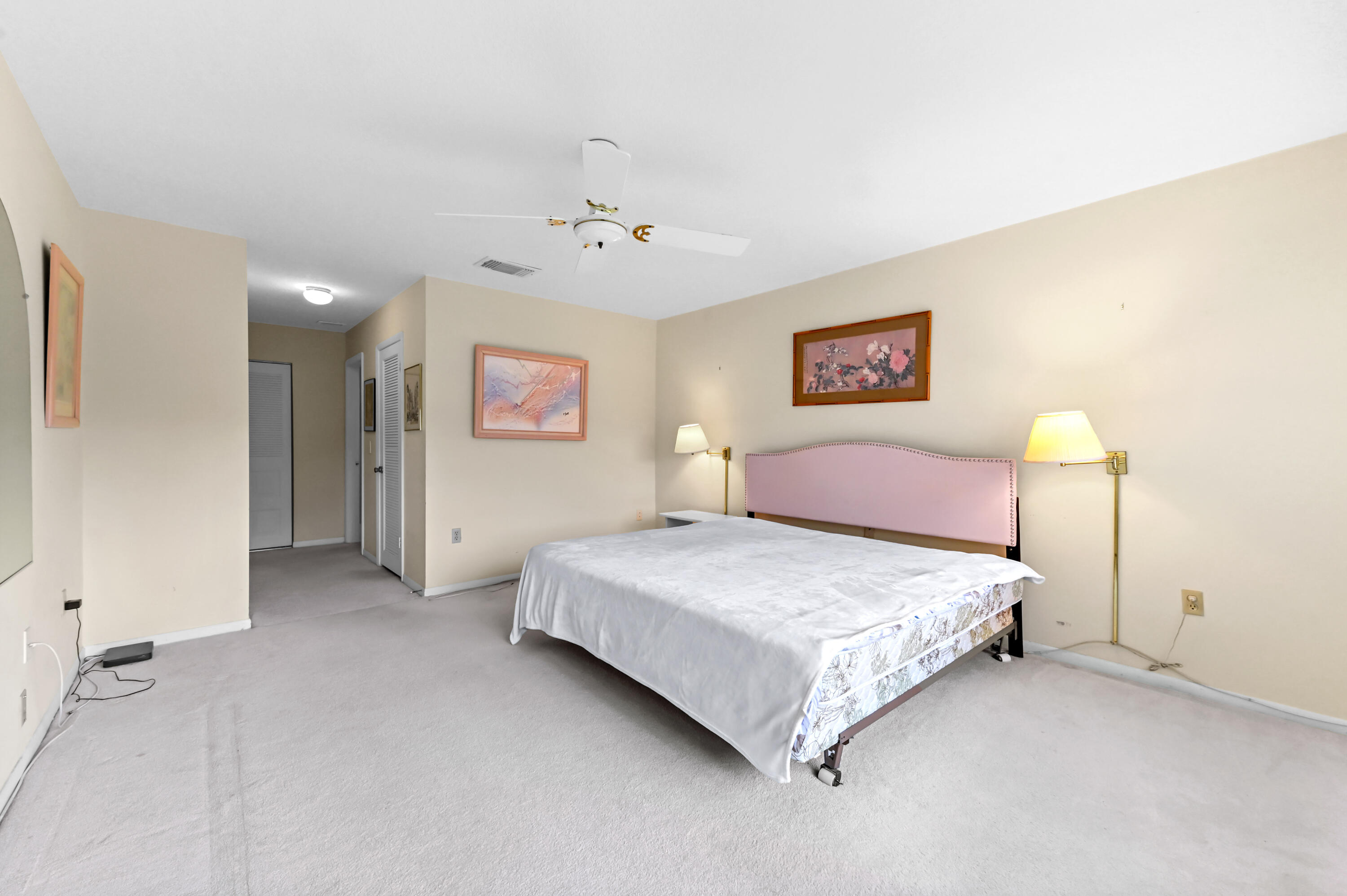 33 Southport Lane, Unit D Boynton Beach, FL 33436 - Photo 18 of 42 a spacious bedroom with a bed and a lamp