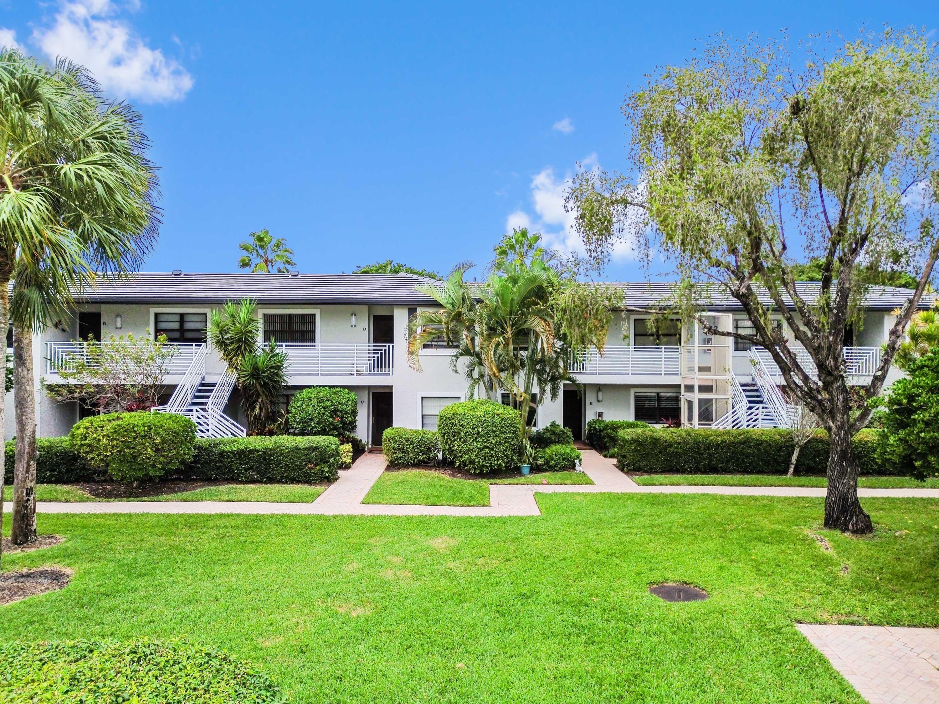 33 Southport Lane, Unit D Boynton Beach, FL 33436 - Photo 34 of 42 a front view of a house with a yard