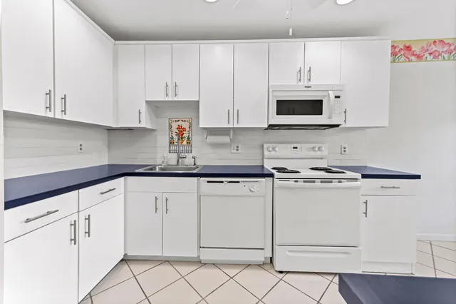a kitchen with white cabinets and white appliances