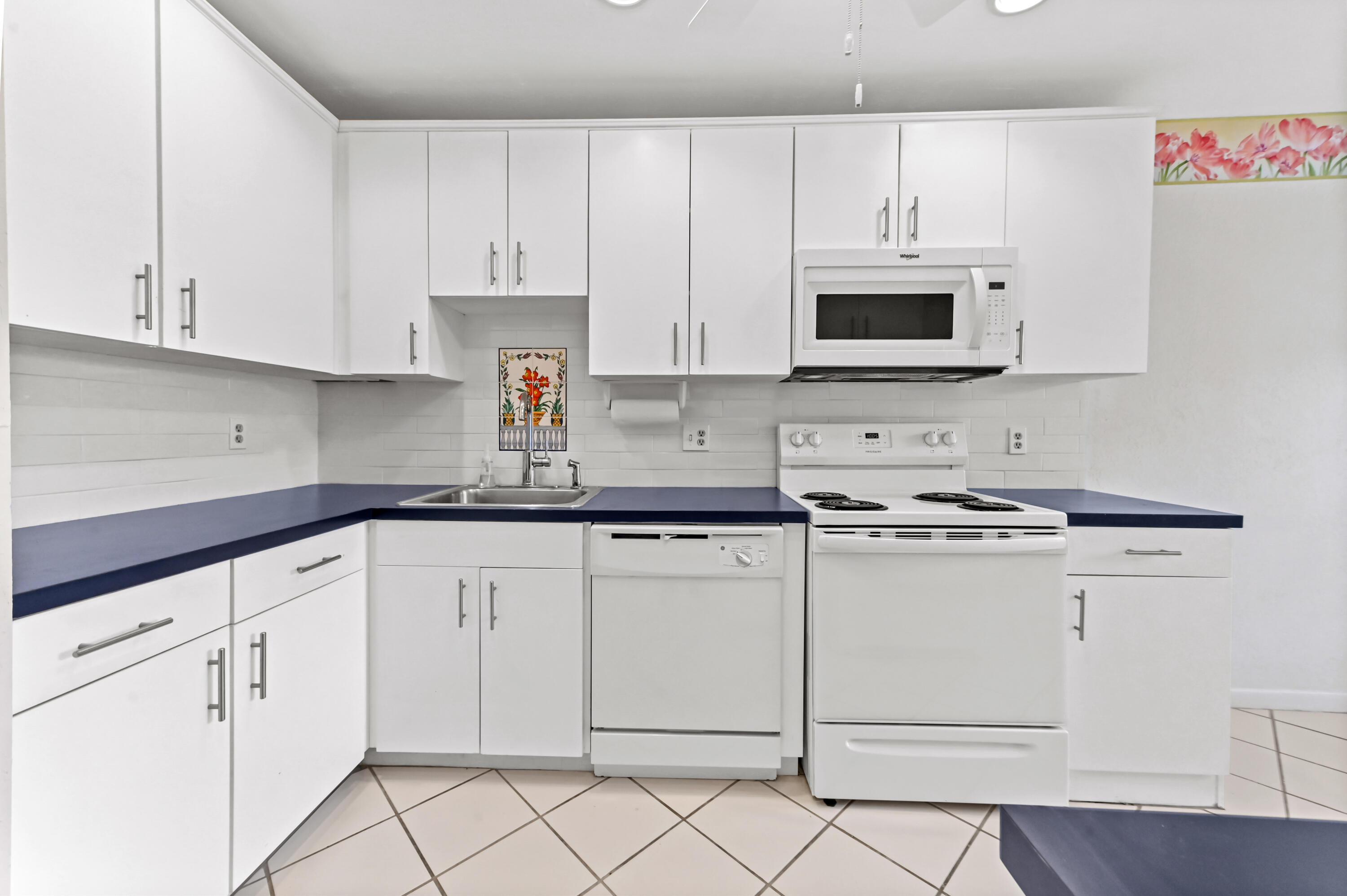 33 Southport Lane, Unit D Boynton Beach, FL 33436 - Photo 6 of 42 a kitchen with white cabinets and white appliances