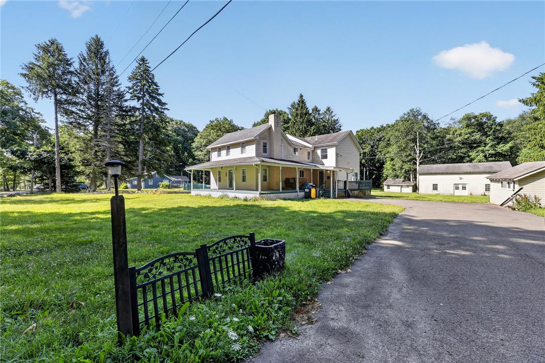 2882 Locust Ridge Road Pocono Lake, PA 18347 - Photo 6 of 45 A spacious home with a charming wrap-around porch set amidst a verdant landscape, complemented by a private driveway.