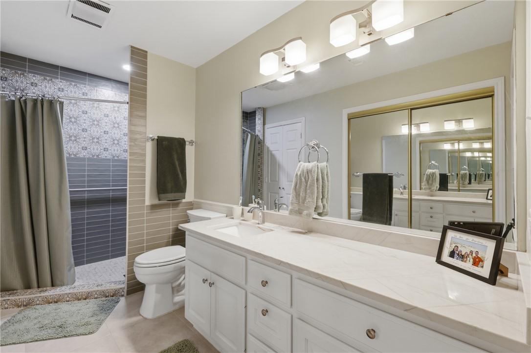 1520 Bennett Street Bryan, TX 77802 - Photo 15 of 24 a bath room with a toilet a sink and a large mirror
