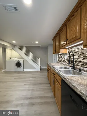 a kitchen with stainless steel appliances granite countertop a sink and a stove