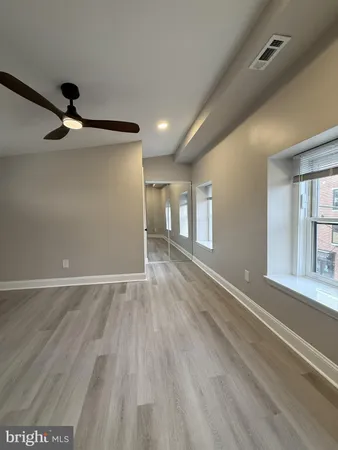 a view of empty room with wooden floor