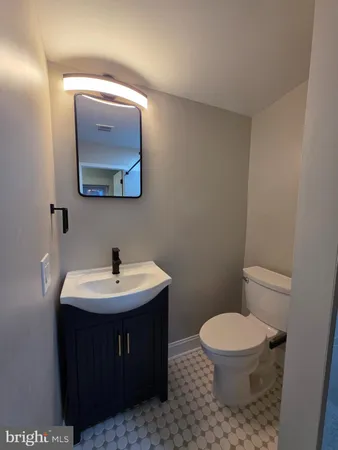 a bathroom with a toilet a sink and mirror