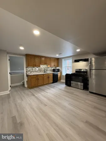 a large kitchen with kitchen island a counter top stainless steel appliances and cabinets