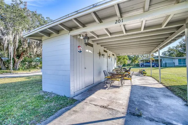 a view of a house with backyard and sitting area