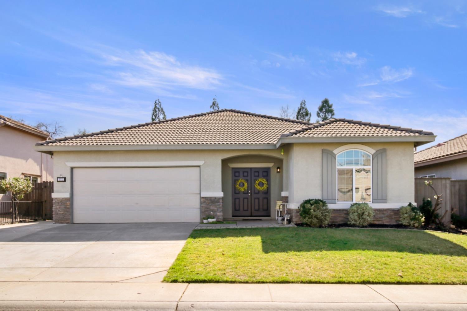 a view of a white house with a large windows and a yard