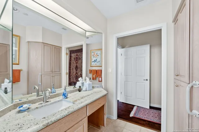 a bathroom with a granite countertop sink and a mirror