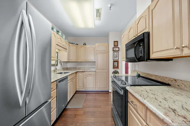 a kitchen with stainless steel appliances granite countertop a refrigerator sink and stove