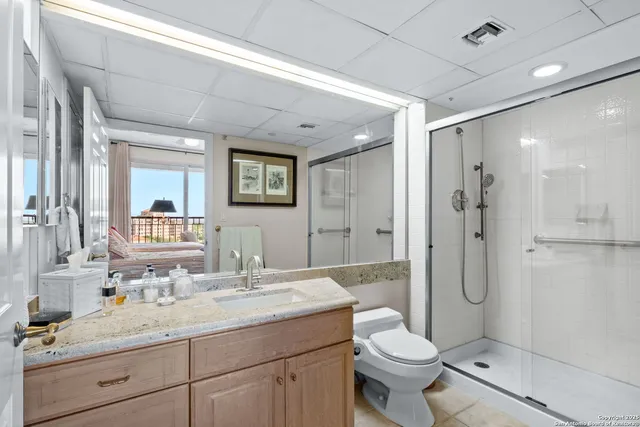 a bathroom with a granite countertop toilet sink and shower