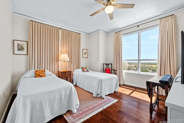 a bedroom with two beds and a large window
