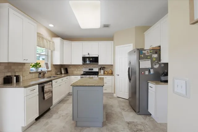 a kitchen with a refrigerator a sink and cabinets