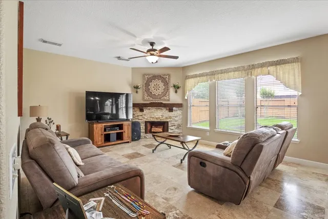 a living room with furniture a fireplace and a large window