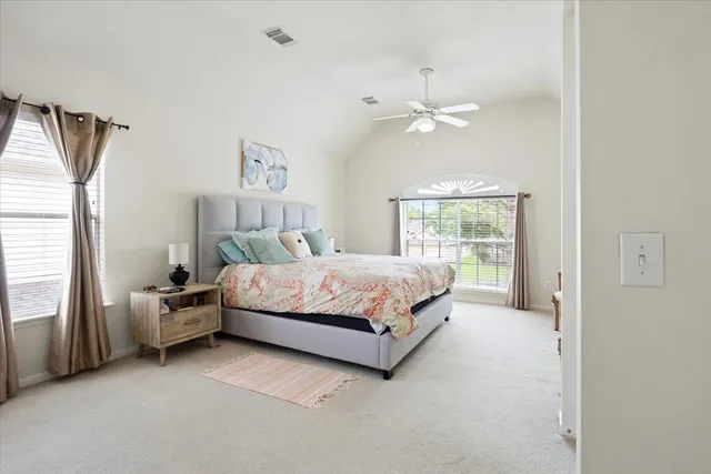 a bedroom with a bed chandelier and a window