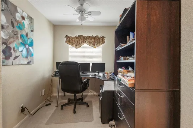 a view of a workspace with furniture and a window