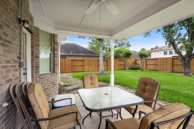 a view of a patio with a table chairs and a backyard