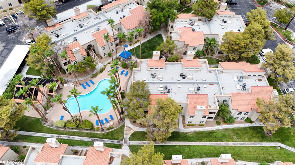 An aerial perspective reveals a vibrant community with a free-form pool and verdant landscaping, connecting multiple residential buildings.