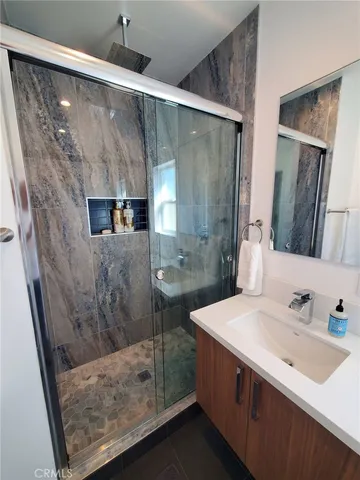 a bathroom with a double vanity sink mirror and shower