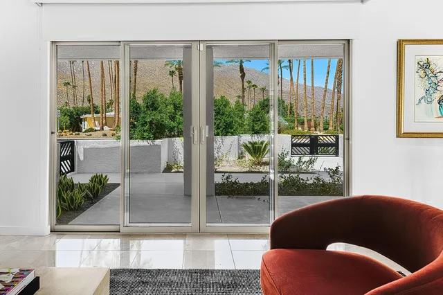 a very nice looking living room with a large window and dining table