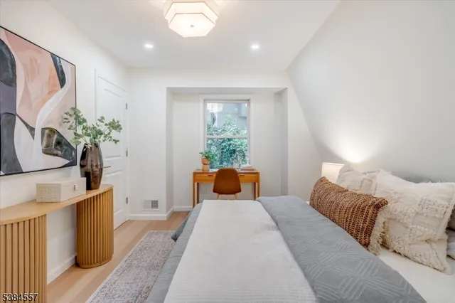 a bedroom with a large bed and a potted plant