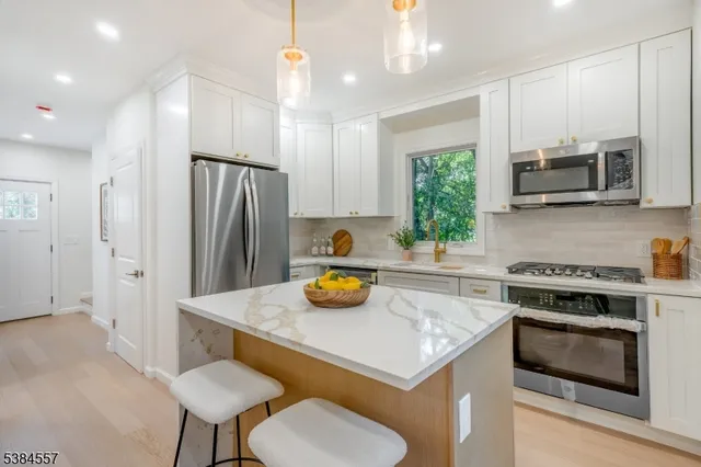 a kitchen with stainless steel appliances a stove a sink and a refrigerator