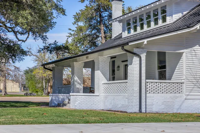 a view of a room with wooden floor chandelier and windows