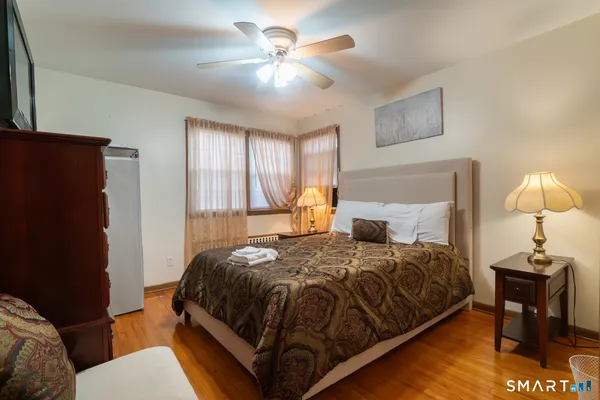 a bedroom with a bed and a lamp on table chair