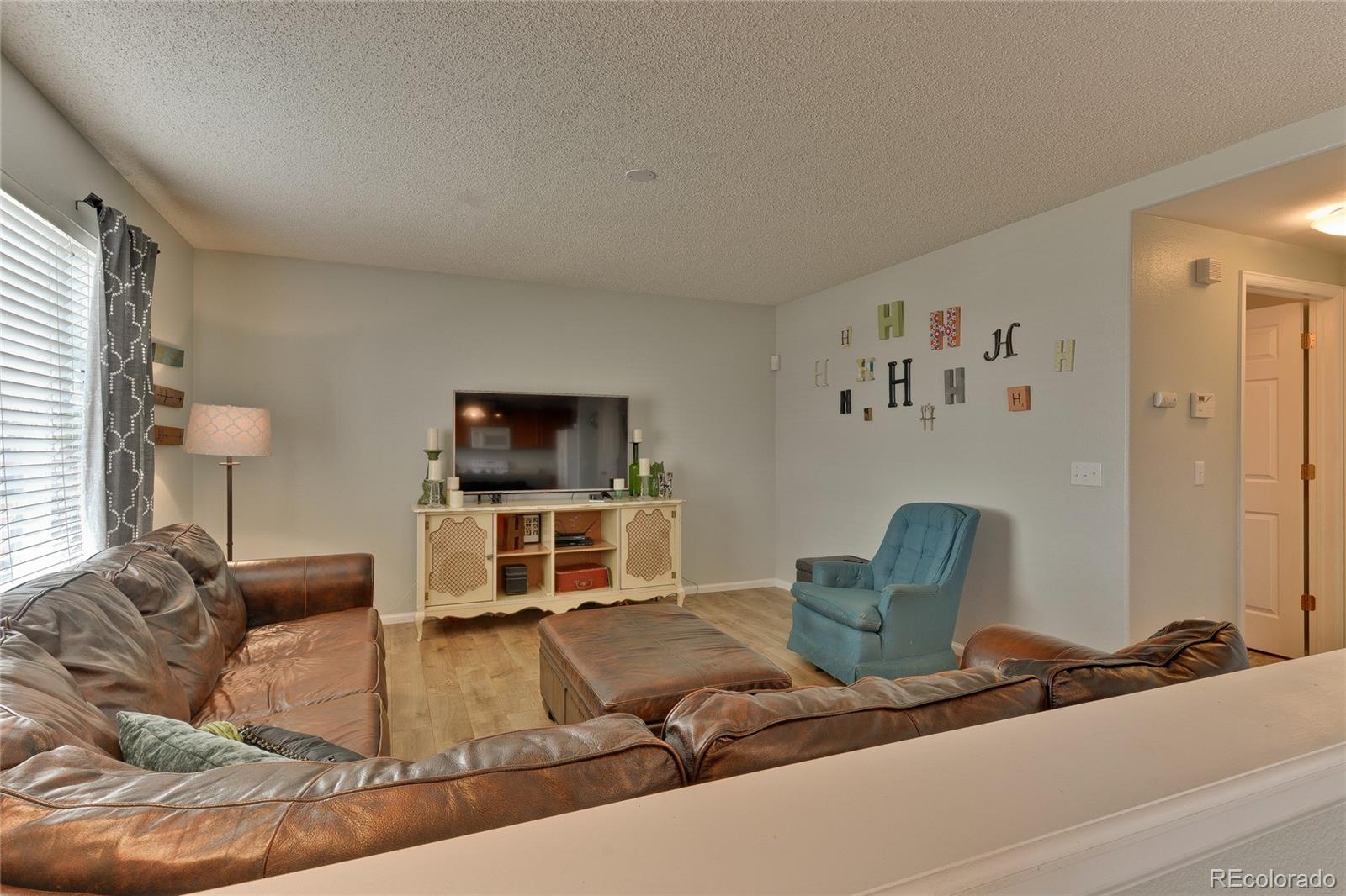 1165 Timbervale Trail Highlands Ranch, CO 80129 - Photo 12 of 29 a living room with furniture and a flat screen tv
