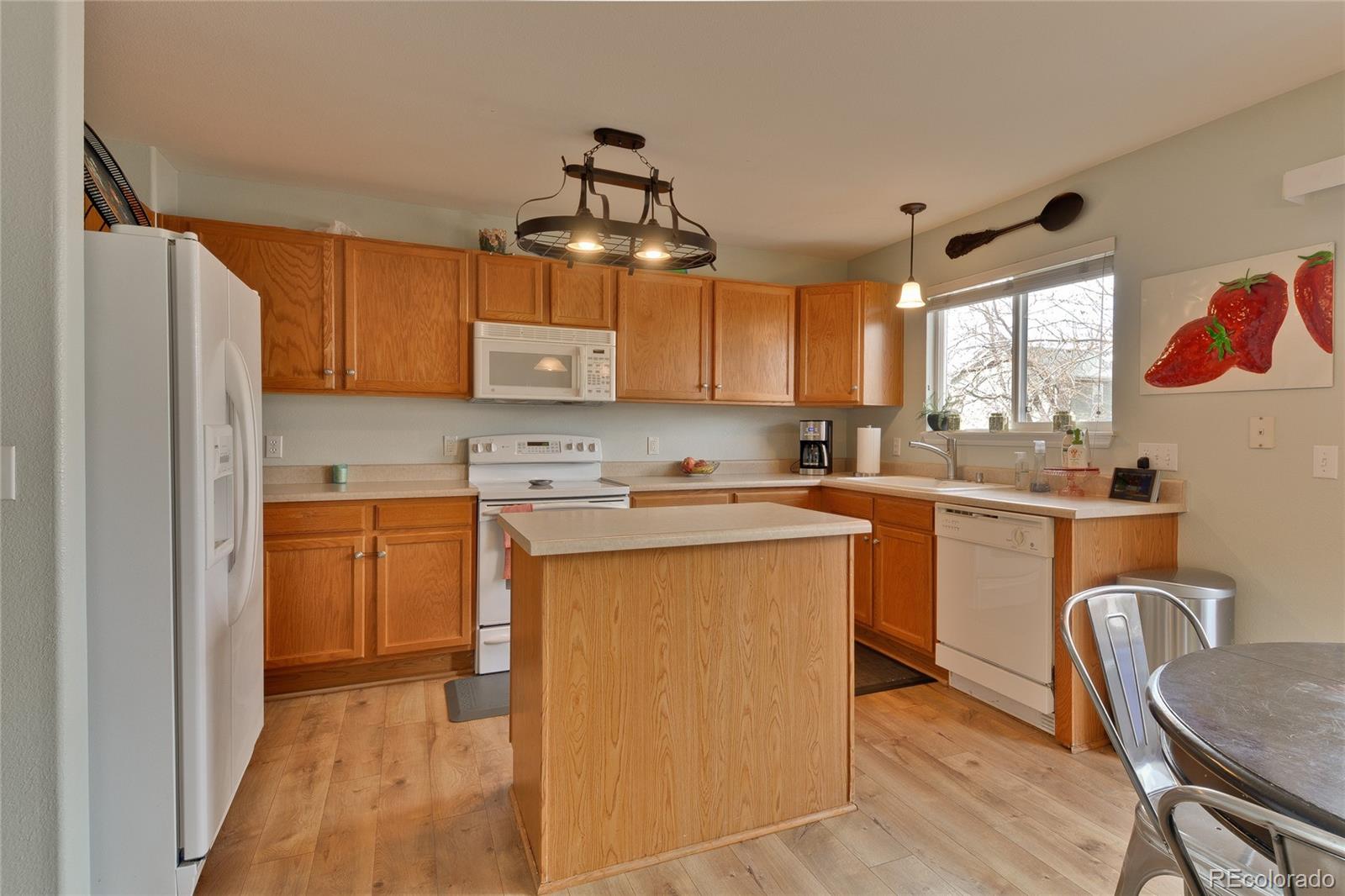 1165 Timbervale Trail Highlands Ranch, CO 80129 - Photo 8 of 29 a kitchen with stainless steel appliances granite countertop a refrigerator sink and wooden cabinets