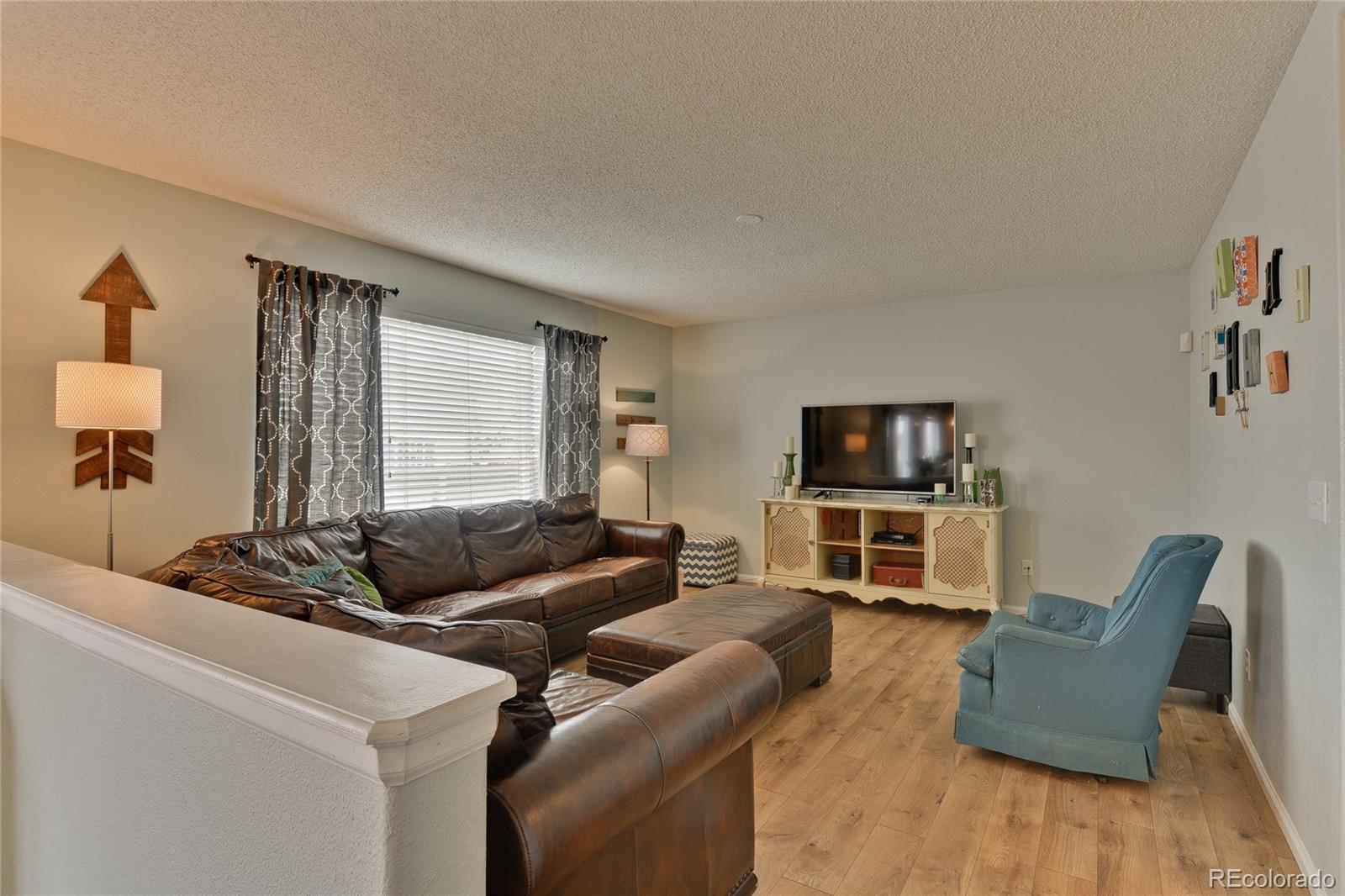 1165 Timbervale Trail Highlands Ranch, CO 80129 - Photo 10 of 29 a living room with furniture and a flat screen tv