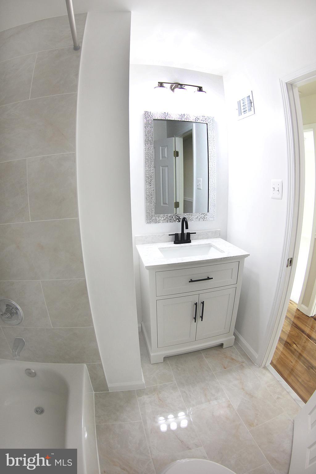 8916 Goldfield Place Clinton, MD 20735 - Photo 14 of 24 a bathroom with a sink a vanity and a mirror