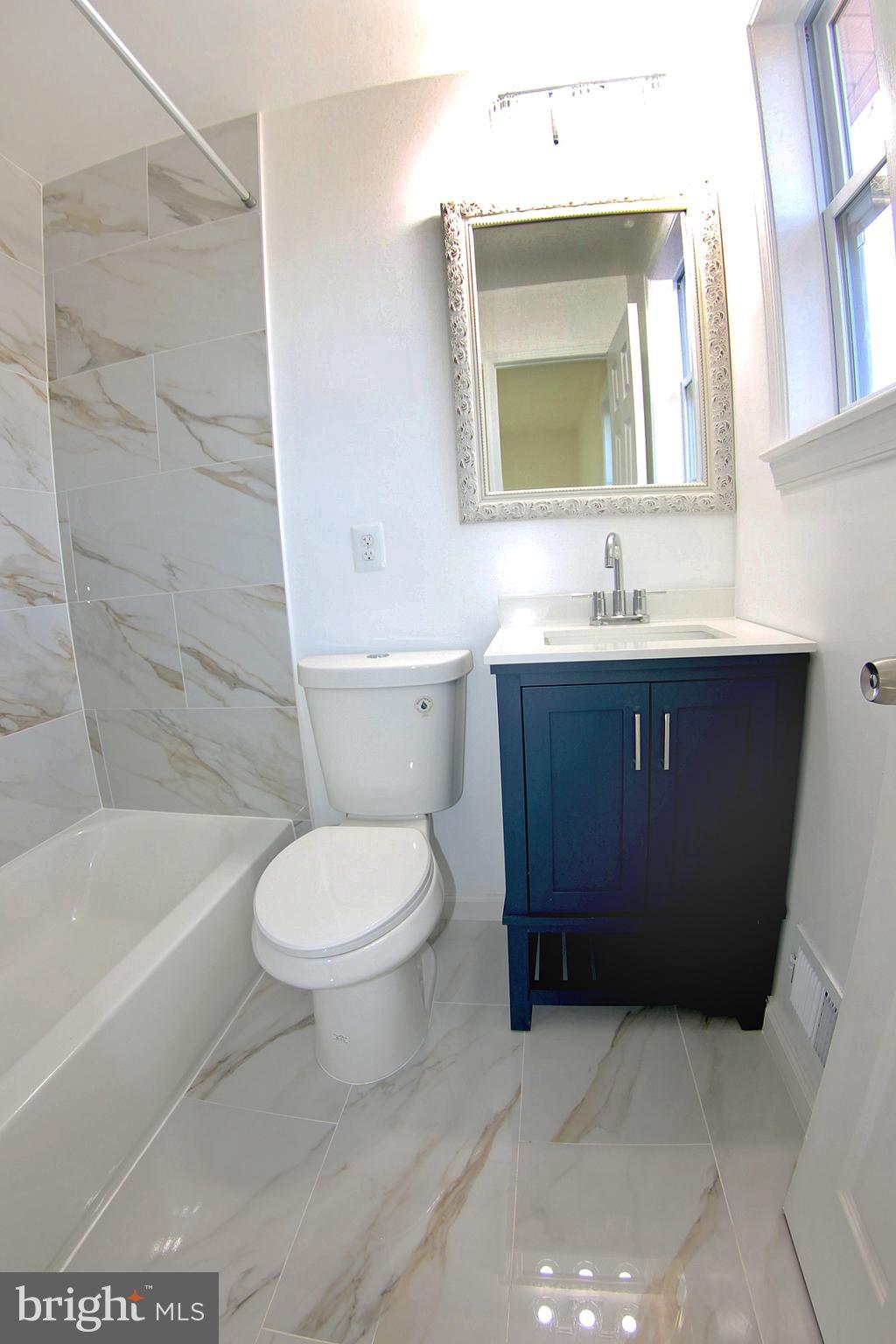 8916 Goldfield Place Clinton, MD 20735 - Photo 17 of 24 a bathroom with a toilet a sink and bathtub