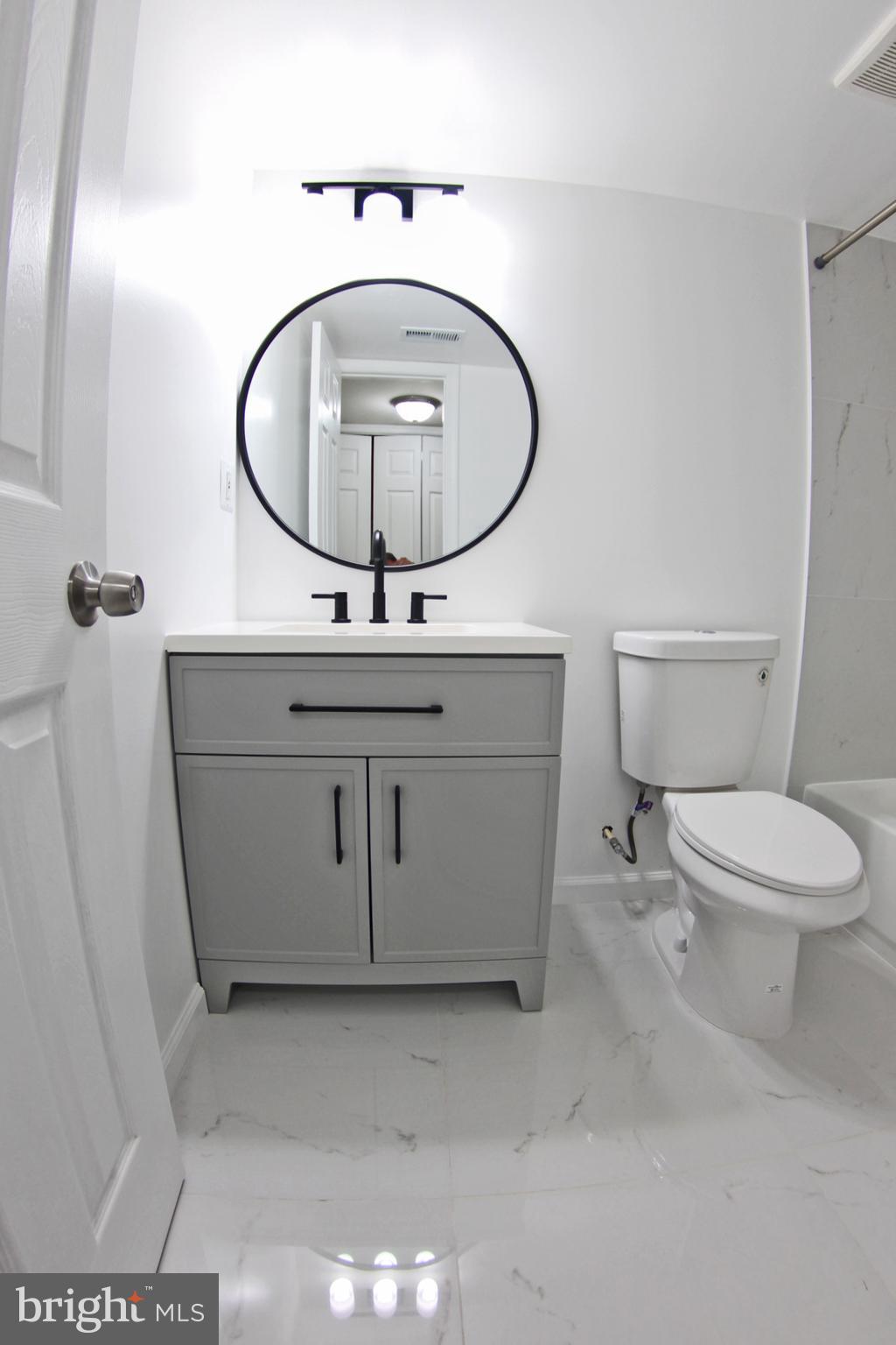8916 Goldfield Place Clinton, MD 20735 - Photo 22 of 24 a bathroom with a toilet a sink and a mirror
