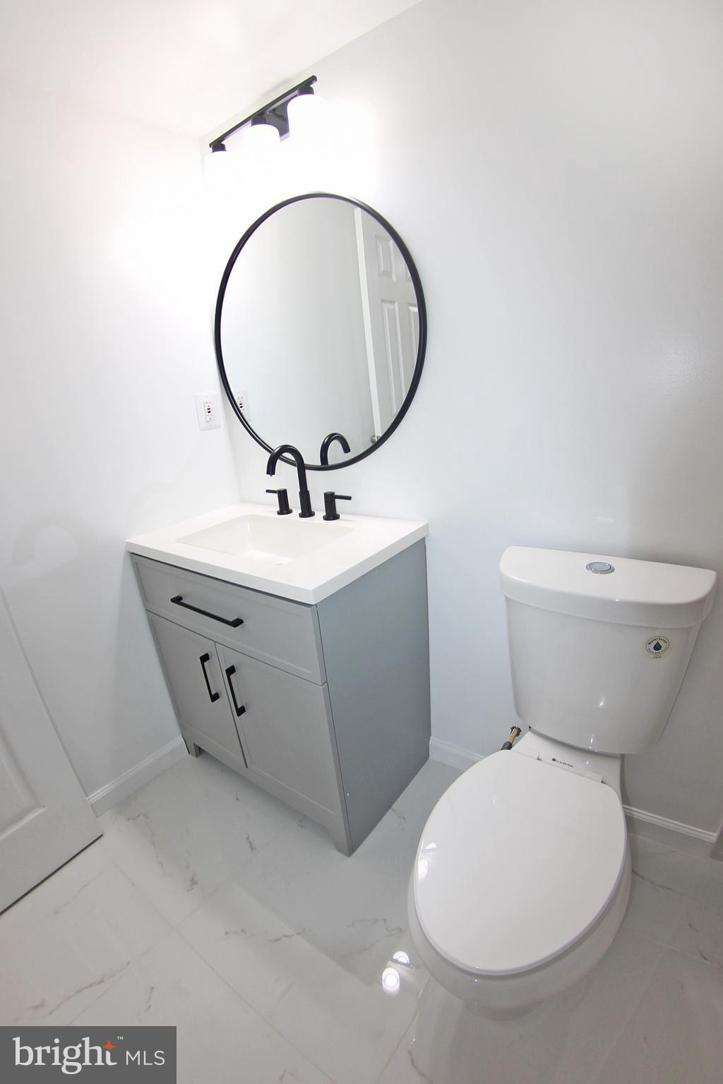 8916 Goldfield Place Clinton, MD 20735 - Photo 23 of 24 a bathroom with a toilet sink and mirror