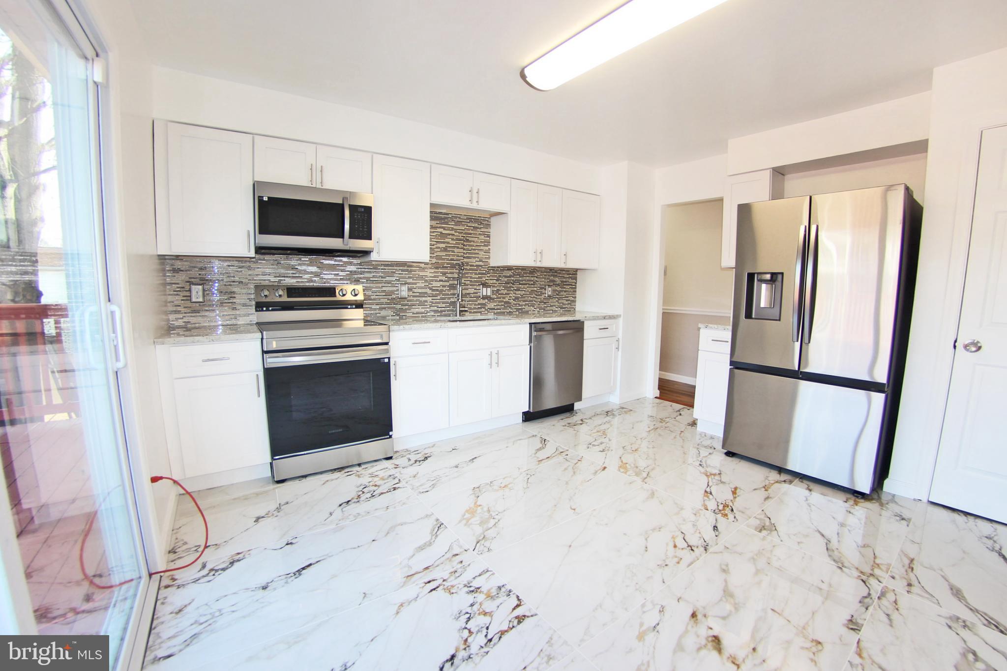 8916 Goldfield Place Clinton, MD 20735 - Photo 6 of 24 a kitchen with stainless steel appliances a refrigerator stove microwave and sink