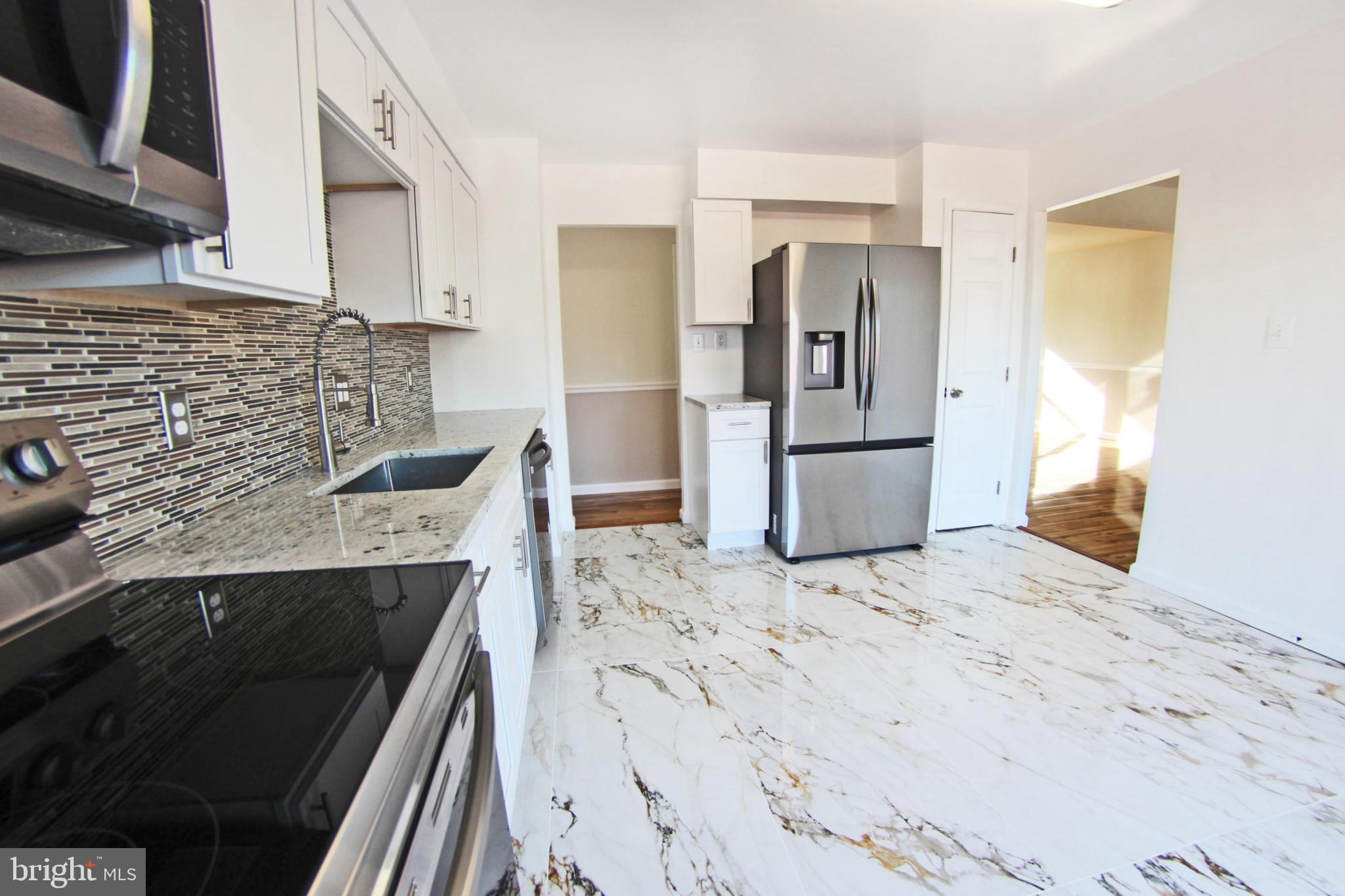 8916 Goldfield Place Clinton, MD 20735 - Photo 8 of 24 a kitchen with a sink stove and refrigerator