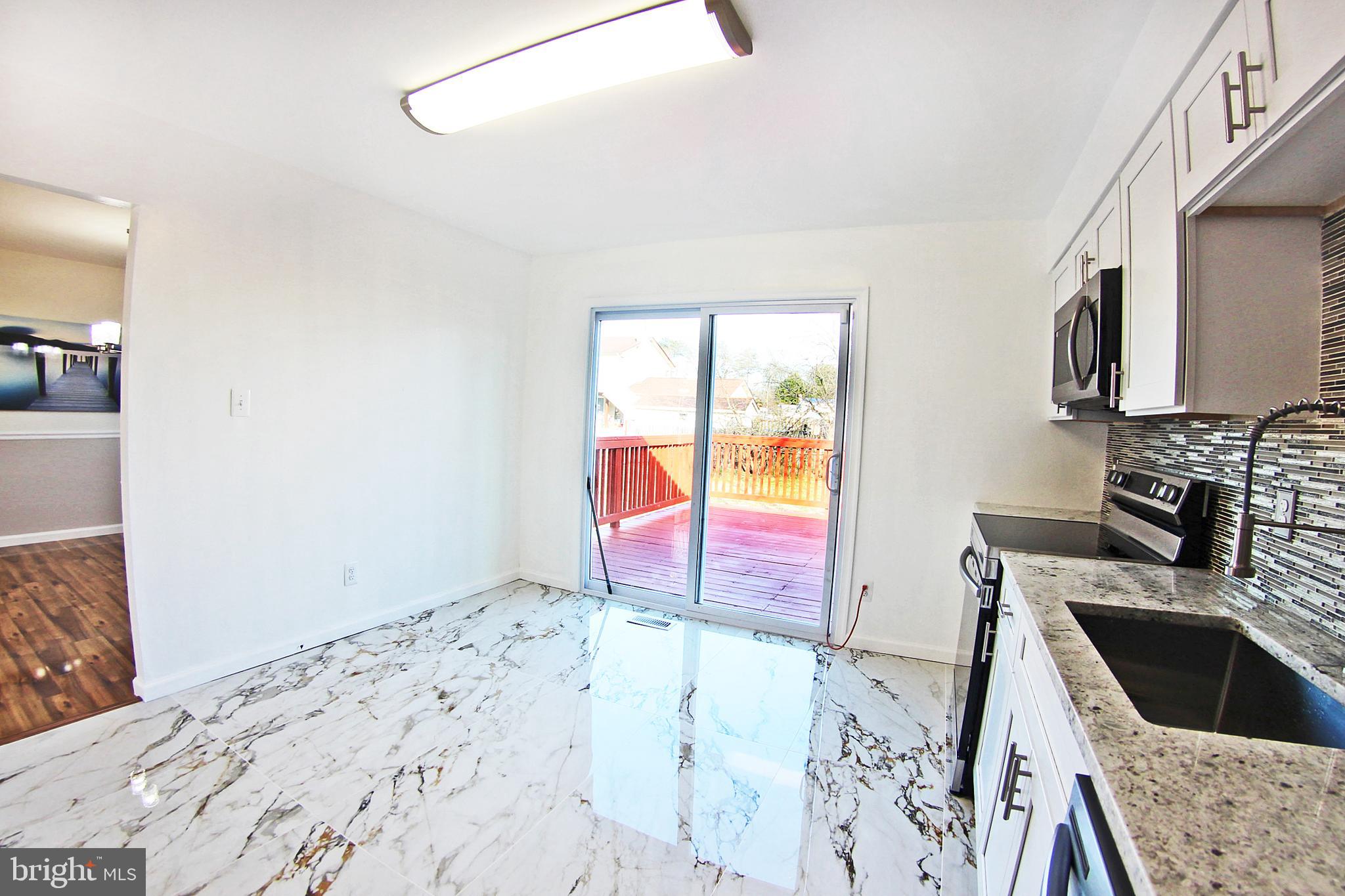 8916 Goldfield Place Clinton, MD 20735 - Photo 9 of 24 a kitchen with stainless steel appliances granite countertop a sink stove and granite countertops with a flat screen tv