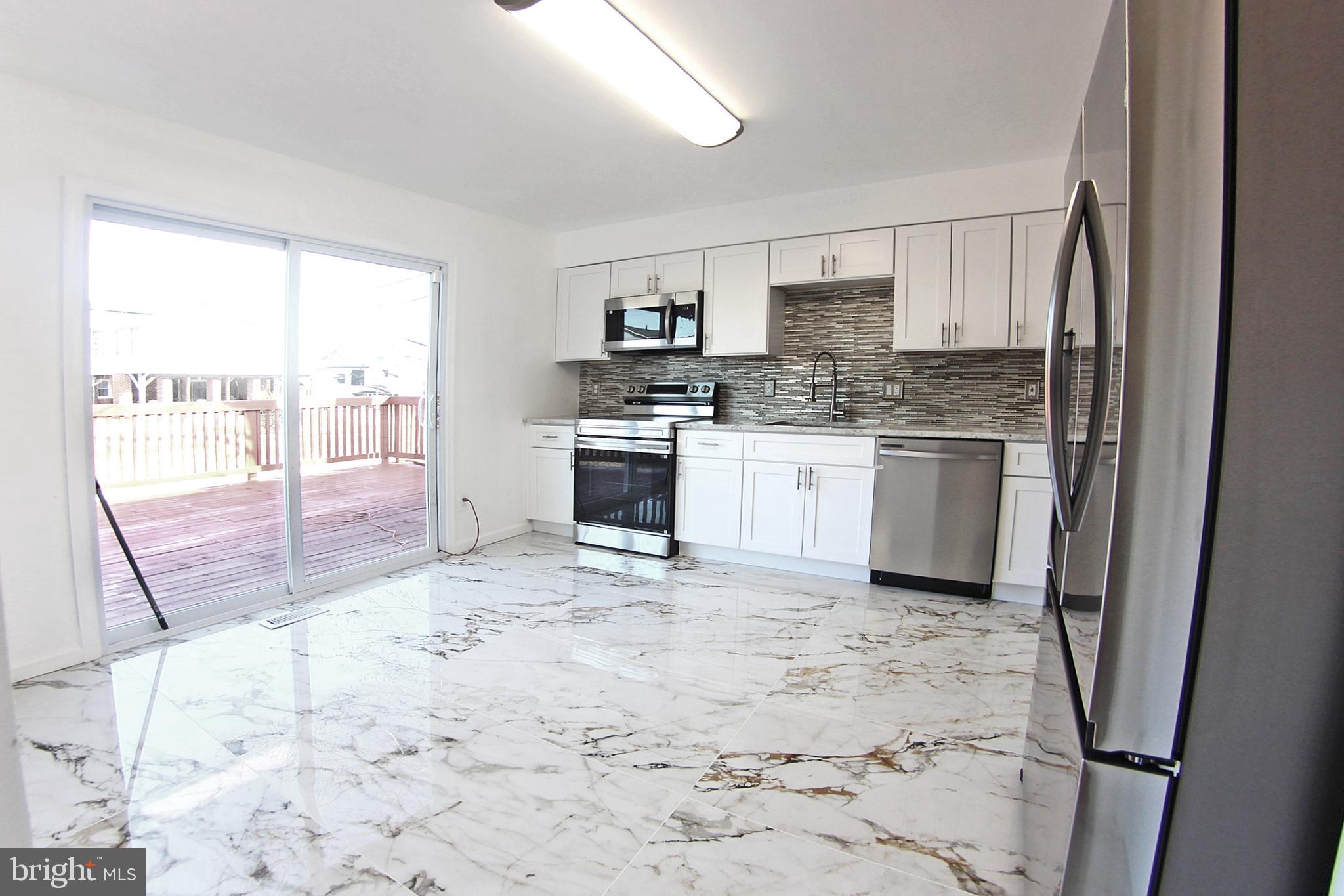 8916 Goldfield Place Clinton, MD 20735 - Photo 10 of 24 a kitchen with stainless steel appliances granite countertop a refrigerator sink and stove
