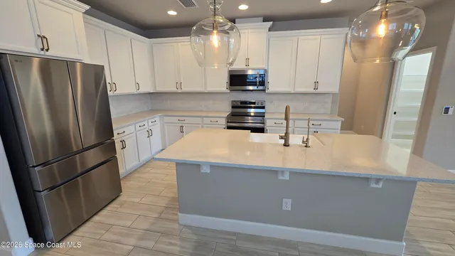 a kitchen with stainless steel appliances a refrigerator a sink a stove a microwave and island