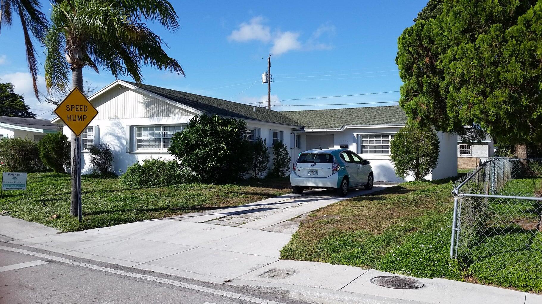 1230 West 23rd Street Riviera Beach, FL 33404 - Photo 1 of 19 a view of a house with backyard and porch