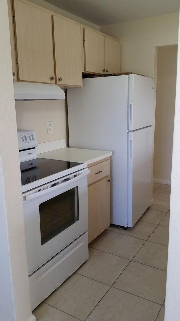 1230 West 23rd Street Riviera Beach, FL 33404 - Photo 5 of 19 a kitchen with a stove top oven and cabinets