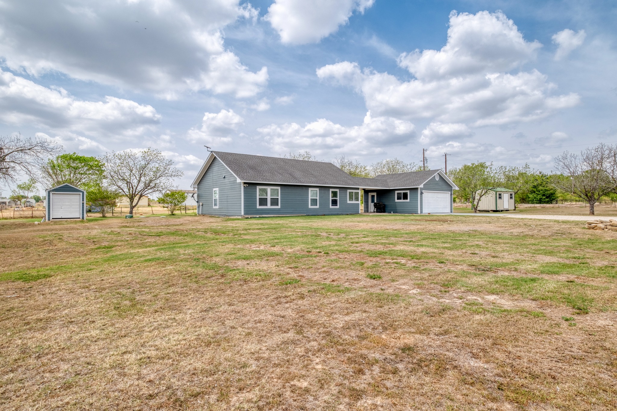 2950 County Road 484 Elgin, TX 78621 - Photo 3 of 25 View of front of home with a storage shed, a front yard, and a garage