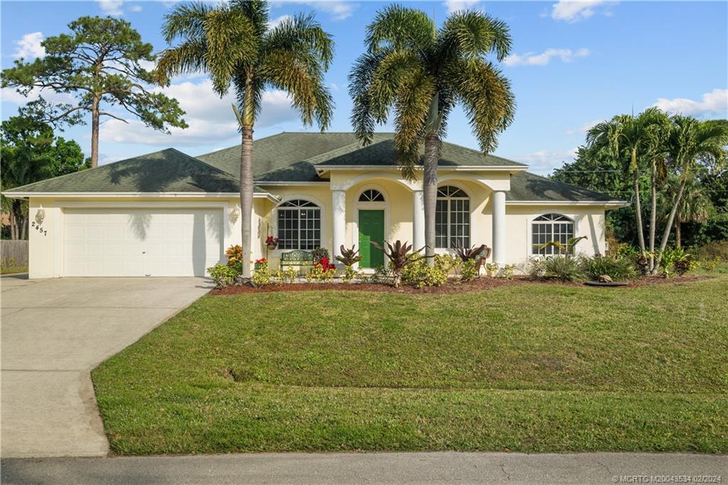 2457 Southeast Issac Road Port St. Lucie, FL 34952 - Photo 1 of 51 a front view of a house with a garden
