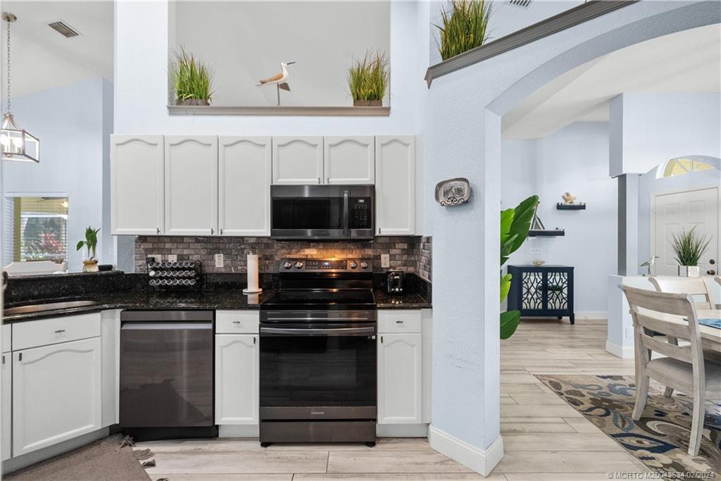 2457 Southeast Issac Road Port St. Lucie, FL 34952 - Photo 14 of 51 a kitchen with stainless steel appliances a stove a sink and a microwave